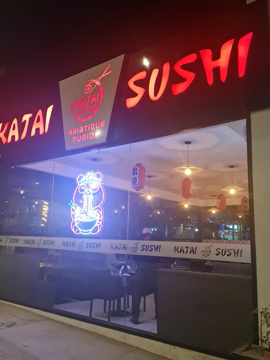 Katai Sushi storefront at night in Agadir — neon sign and lanterns