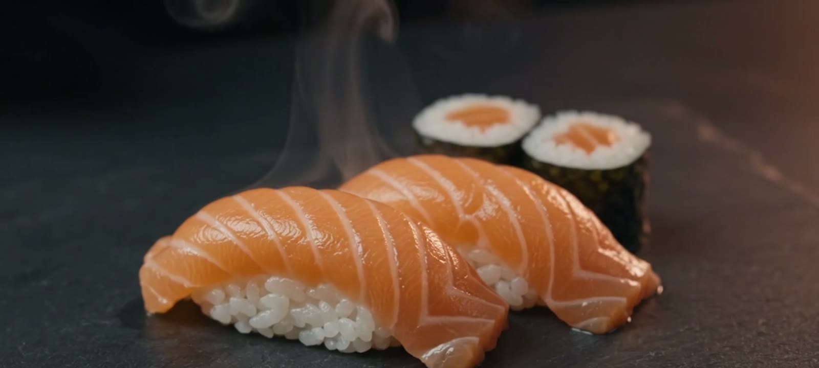 A chef placing salmon nigiri at Katai Sushi